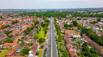 aéreo Visão do uma suburbano área com linhas do casas e uma a Principal estrada corte através a paisagem, exibindo residencial planejamento dentro Londres. foto