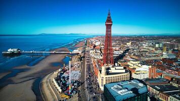 aéreo Visão do uma costeiro cidade com uma proeminente torre, azul céus, e uma beira-mar dentro pool de apoio, Inglaterra. foto