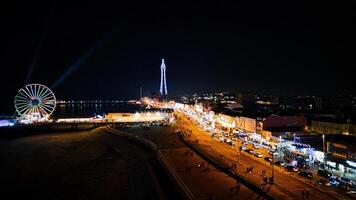 período noturno paisagem urbana com iluminado ferris roda e torre, movimentado rua, e vibrante luzes dentro pool de apoio, Inglaterra. foto