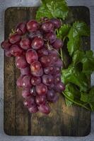 uma grupo do uvas em uma de madeira corte borda foto