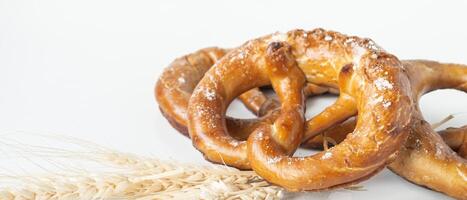 uma pretzel e trigo em uma branco fundo foto