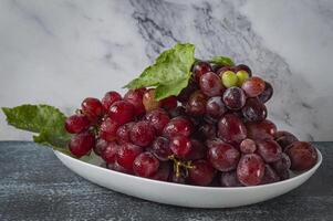 uma tigela do uvas em uma mesa foto