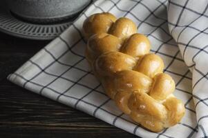 pão em uma mesa com uma copo do café foto