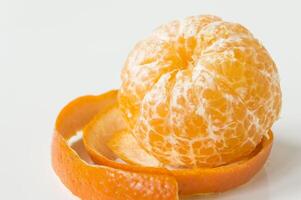 uma descascado laranja em uma branco superfície foto