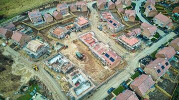 aéreo Visão do uma residencial construção local com parcialmente concluído casas e a infraestrutura. foto