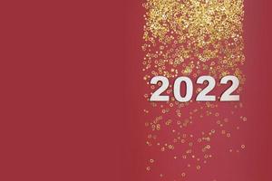 Números do ano novo 2022 em fundo vermelho com espaço de cópia de estrelas douradas foto