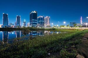 ho chi minh cidade Horizonte e a Saigon rio. surpreendente colorida noite Visão do arranha-céu e de outros moderno edifícios às centro da cidade foto