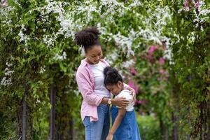 africano mãe e dela filha abraçando cada de outros com calmante palavra depois de a criança veio costas a partir de escola e obteve intimidado a partir de amigo para família amor, Apoio, suporte e Cuidado foto