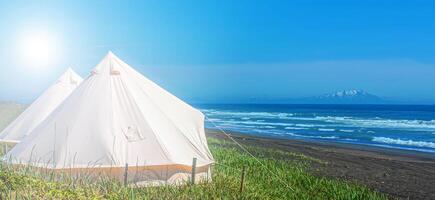 branco glamping tendas contra a pano de fundo do a pacífico oceano em a Kamchatka península foto