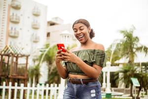 animado mulher segurando telefone olhando às telefone surpreso de SMS. foto