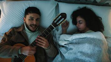 homem cantar e jogar a guitarra dentro uma cama foto