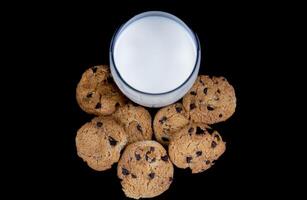 biscoitos e leite isolado em Preto fundo foto