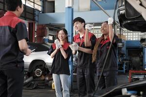 masculino profissional Supervisor engenheiro e mecânico trabalhadores estão alegre com acabado reparar trabalhar, trabalho em equipe conquistas às carro serviço garagem, e harmonioso manutenção empregos dentro automotivo indústria. foto