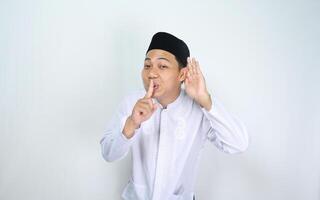 atraente muçulmano homem ásia espionagem e mostrar silencioso gesto isolado em branco fundo foto