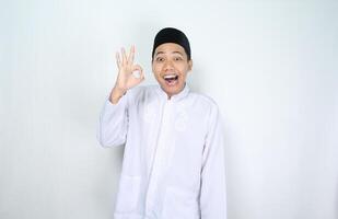 engraçado muçulmano homem ásia dar OK sinais com surpreso expressão isolado em branco fundo foto