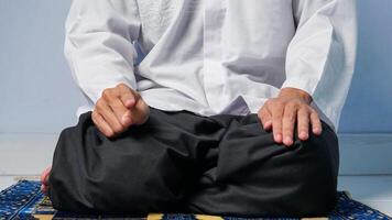 fechar acima do muçulmano homem Rezar em oração esteira e fazendo último movimento em oração procedimento foto