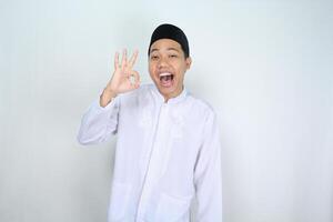 muçulmano ásia homem gritando enquanto dando OK sinais isolado em branco fundo foto