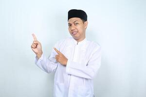 confuso ásia muçulmano homem apontando para lado isolado em branco fundo foto