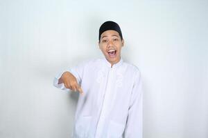 atraente muçulmano ásia homem apontando baixa e gritando com boca aberto isolado em branco fundo foto