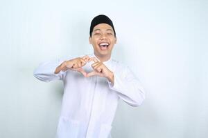 animado ásia muçulmano homem mostrando coração forma isolado em branco fundo foto