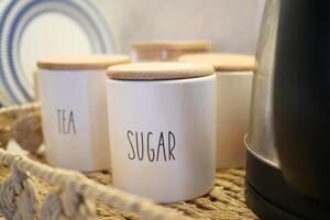 uma vime cesta com chá e açúcar frascos para uma encantador chá evento foto