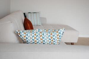 moderno sofá com almofadas dentro vivo quarto às casa foto