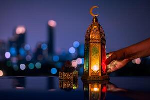 lanterna segurando de mão e pequeno prato do datas fruta em mesa com noite céu e cidade bokeh luz fundo para a muçulmano festa do a piedosos mês do Ramadã kareem. foto