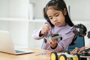 haste Educação conceito. ásia jovem menina Aprendendo robô Projeto. foto