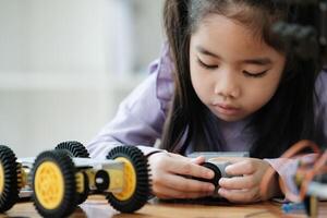 haste Educação conceito. ásia jovem menina Aprendendo robô Projeto. foto