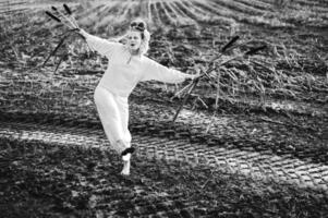 alegre jovem mulher com palhetas danças dentro colori fumaça dentro uma campo. foto