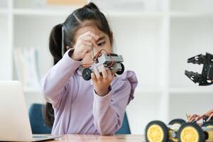 haste Educação conceito. ásia jovem menina Aprendendo robô Projeto. foto