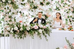 roubado momentos às seus Casamento recepção. jovem Casamento casal levantando champanhe óculos durante Casamento celebração foto