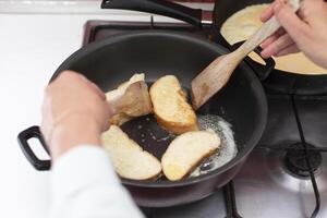 fritar branco pão croutons dentro uma fritar frigideira. cozinhar café da manhã. foto