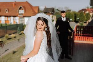 a noiva é vestido dentro a elegante exuberante branco Casamento vestir com uma grandes véu e é pronto para dela noivo. a primeiro encontro do a noiva e noivo foto