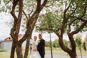 feliz casal a comemorar seus Casamento ao ar livre. surpreendente sorridente Casamento casal. bonita noiva e à moda noivo. Casamento retrato. foto