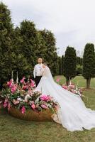 a noiva e noivo abraçar. a noiva suavemente abraços a noivo de a ombros. lindo Casamento casal. a conceito do romance dentro uma recém-casados relação. lua de mel. foto