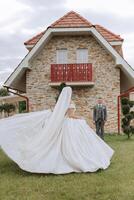 a noiva é vestido dentro a elegante exuberante branco Casamento vestir com uma grandes véu e é pronto para dela noivo. a primeiro encontro do a noiva e noivo foto