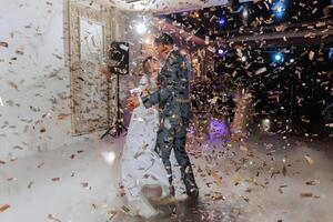 Casamento dança do a noiva e noivo. a primeiro dança do a noiva e noivo dentro a elegante Casamento corredor com a usar do pesado fumaça e pirotecnia luzes, confete. foto