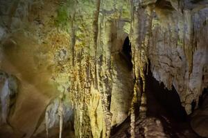 a caverna é cársico, surpreendente Visão do estalactites e estalagnites iluminado de brilhante luz, uma lindo natural atração dentro uma turista lugar. foto