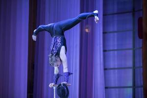 bielorrússia, gomel, Julho 4, 2018. indicativo Treinamento circo escola.acrobático desempenho do a atriz.menina com uma flexível corpo.equilíbrio ato.twine figura em etapa foto