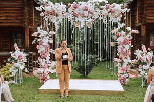 Casamento cerimônia dentro natureza. a mestre do cerimônias às a Casamento durante a discurso convida a noiva e noivo para a cerimônia. foto