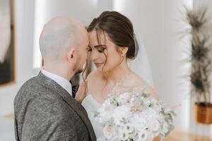 a noiva é vestido dentro a elegante exuberante branco Casamento vestir com uma grandes véu e é pronto para dela noivo. a primeiro encontro do a noiva e noivo foto