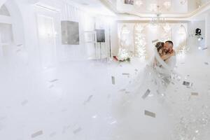 Casamento dança do a noiva e noivo. a primeiro dança do a noiva e noivo dentro a elegante Casamento corredor com a usar do pesado fumaça e pirotecnia luzes, confete. foto