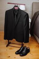 Preto masculino terno. a homem é pronto para vestem uma o negócio terno, branco camisa e gravata. uma Preto Jaqueta em uma manequim foto