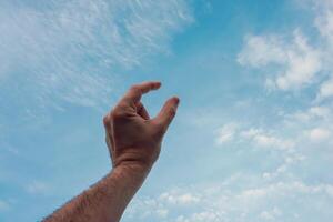 homem mão gesticulando em a azul céu foto