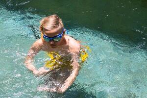 Adolescência Garoto jogando dentro natação piscina. foto