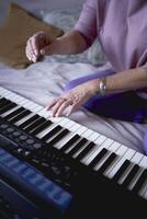 uma 60 anos mãe e uma 40 anos filha jogar a teclado juntos em a cama às casa foto