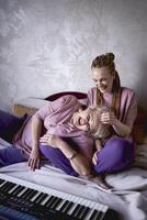 uma 60 anos mãe e uma 40 anos filha jogar a teclado juntos em a cama às casa foto