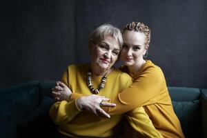 à moda velho mãe e meia idade filha dentro amarelo blusas abraço e conforto cada de outros dentro uma cafeteria foto