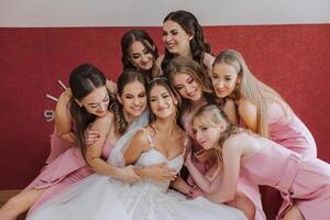 uma lindo noiva e dela damas de honra estão tendo Diversão dentro a manhã. Casamento celebração. feliz meninas às seus melhor amigos casamento. uma lindo e elegante noiva com dela damas de honra foto